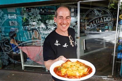 Esteban Salgado, fundador del restaurante, con un plato de raviolones de ternera con tuco gratinados con queso provolone