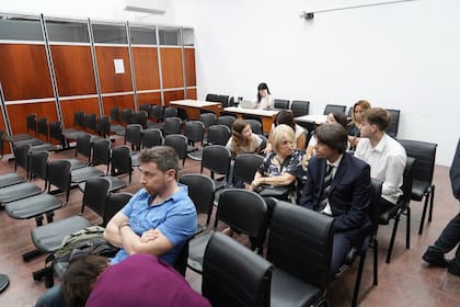 Esteban Wolfenson, el hijo de la víctima (de camisa celeste de mangas cortas) y Graciela Orlandi (la mujer que conversa con un hombre vestido de traje) en la sala de audiencias de los tribunales de San Isidro