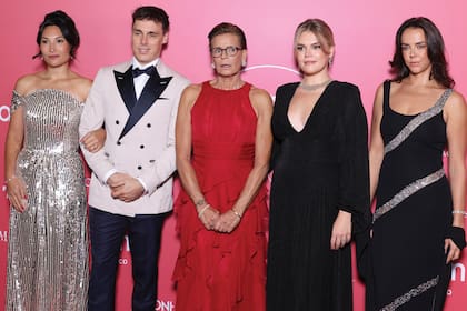 Estefanía posa con sus hijos y su nuera. De izquierda a derecha: Marie Chevallier, la nuera de la princesa, que optó por un vestido largo plateado cubierto de lentejuelas, su marido, Louis Ducruet, con un smoking bicolor, la propia Estefanía, y sus hijas mujeres, Camille Gottlieb, con un vestido negro largo de pronunciado escote, y Pauline Ducruet, que recicló un diseño que su madre estrenó en El Baile de la Rosa 2003, también negro, de silueta ajustada y atravesado por varias bandas diagonales de pedrería plateada