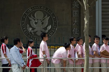 Estudiantes chinos aguardan afuera de la embajada de Estados Unidos para sus entrevistas de solicitud de visa