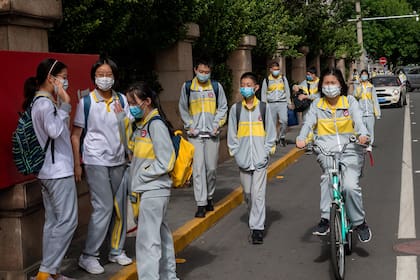 Estudiantes con máscaras faciales en medio de preocupaciones por el coronavirus abandonan una escuela secundaria en Pekín el 11 de mayo de 2020