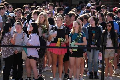 Estudiantes de la Universidad de Georgia se reúnen para rendir homenaje a Laken Riley en la Plaza Tate del campus de Athens, Georgia, el lunes 26 de febrero de 2024. (Nell Carroll/Atlanta Journal-Constitution via AP)
