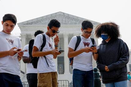 Estudiantes de la Universidad Washington Adventist miran sus teléfonos mientras se divulga la noticia de la decisión de la Corte Suprema relacionada con la discriminación positiva frente al Edificio de la Corte Suprema de los Estados Unidos el 29 de junio de 2023 en Washington, DC.