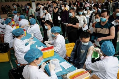 Estudiantes hacen fila para recibir la vacuna Covid-19 del Grupo Nacional Biotec de China (CNBG) en una universidad de Wuhan