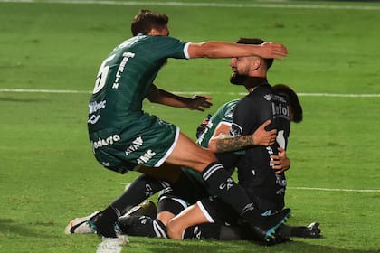 Manuel Vicentini, abrazado por sus compañeros, después de atajar el penal decisivo y darle el ascenso a Sarmiento.