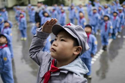 Estudiantes se reúnen para la ceremonia de izar la bandera, en la escuela primaria del "ejército rojo"
