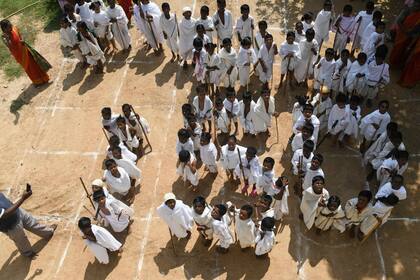 Estudiantes vestidos como Mahatma Gandhi hicieron una muestra en su escuela por el aniversario del nacimiento del activista