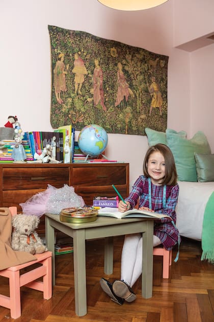 Eugenia, de 7 años, en su dormitorio, decorado con un gobelino del siglo XIV y su colección de figuras de Lladró, que están sobre la cómoda.