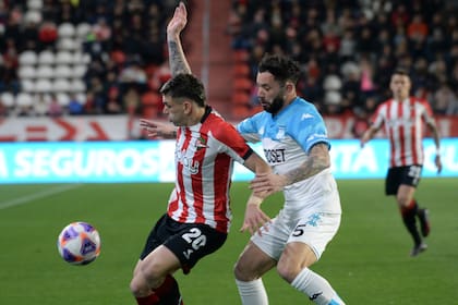 Eugenio Mena, lateral de Racing, intenta marcar a Manuel Castro
