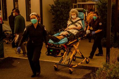 Evacuación de una persona de una residencia de ancianos cuando se aproxima el incendio Eaton, el miércoles 8 de enero de 2025, en Altadena, California