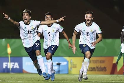 Exequiel Zeballos, Matías Godoy y Juan Pablo Krilanovich celebran uno de los goles con que la Argentina se impuso a Camerún por 3 a 1, tras estar en desventaja en Brasil.