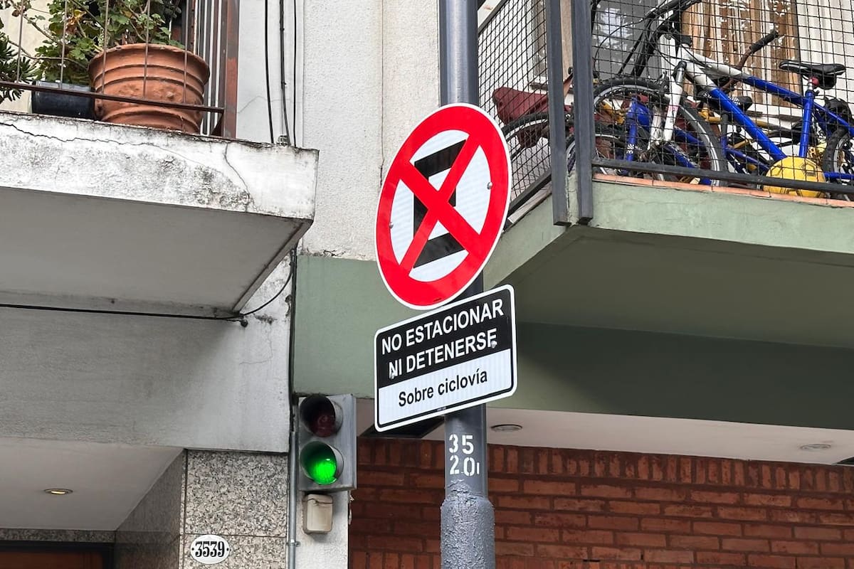 Existe un cartel de tránsito que indica la prohibición de detenerse o estacionar sobre una ciclovía
