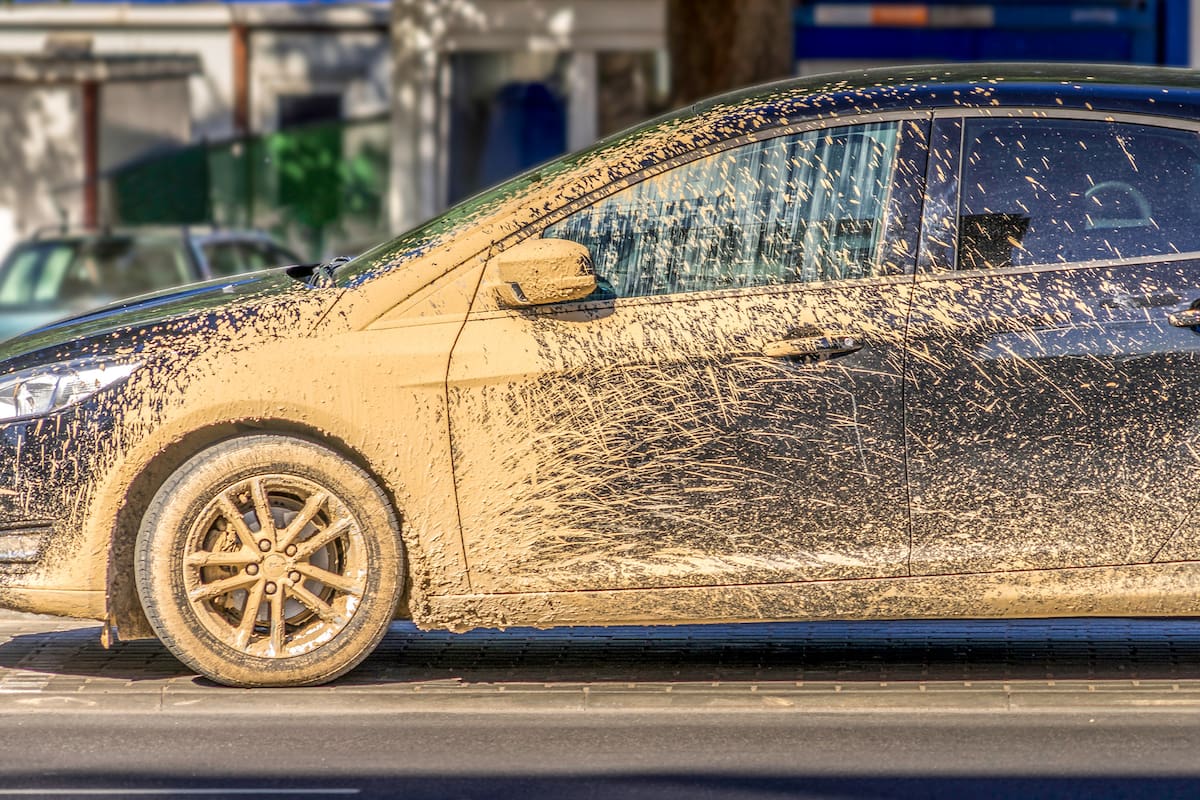 Extremely dirty car after driving on unrepaired damaged road