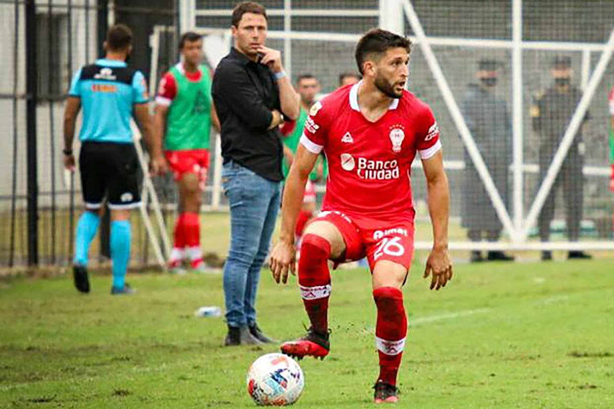 Ezequiel Bonifacio domina la pelota y otea el panorama; Israel Damonte lo observa en el último partido de su ciclo como entrenador de Huracán.