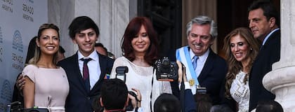 Fabiola Yáñez, en rosa pálido; el hijo del presidente, con traje y pañuelo insignia de la comunidad LGBTIQ; Cristina, de blanco total y el Presidente con corbata celeste; Claudia Ledesma, con vestido de falda plato