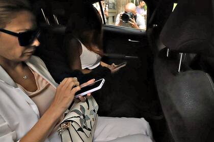 Fabiola Yañez porta su teléfono celular al salir del consulado argentino en Madrid, donde declaró en la causa