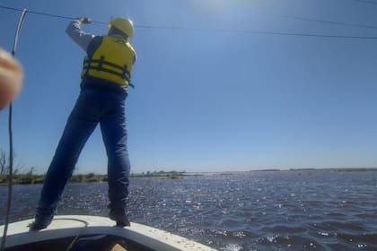 Fabricio Bonello y el equipo de la cooperativa mientras hacían tareas sobre un bote