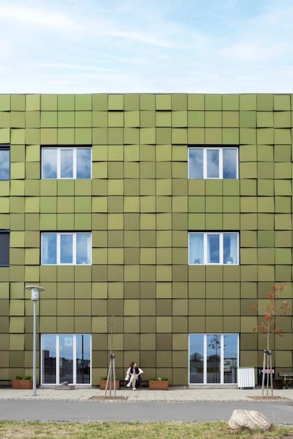 Fachada del Hospital de Bornholm en Dinamarca, compuesta por 500 paneles solares inclinados, con acabado satinado y recubrimiento estructural de color que produce un efecto tornasolado. Además de generar energía, aporta aislamiento térmico al edificio (SolarLab)