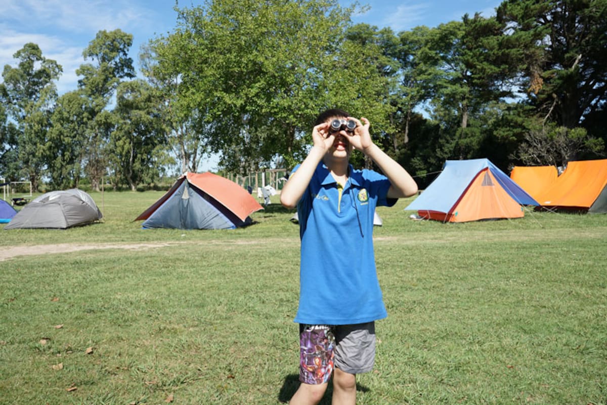 Facundo Abdo onserva su entorno con unos binoculares en el predio de Kapawa Camp, en Chascomús"