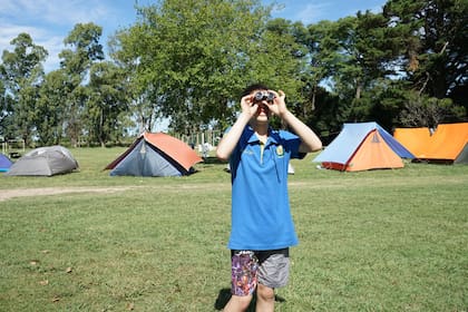 Facundo Abdo onserva su entorno con unos binoculares en el predio de Kapawa Camp, en Chascomús"