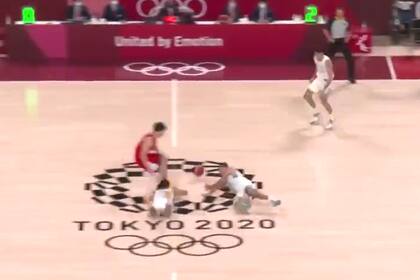 Facundo Campazzo (izquierda) y Luis Scola (derecha) se van al suelo para asegurarse la pelota ante un japonés; la jugada más espectacular del partido terminó con un triple argentino en los Juegos Olímpicos Tokio 2020.