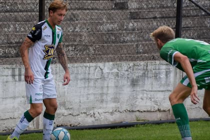 Facundo Castillón (Nueva Chicago) maniobra con la pelota ante la marca de Rodrigo Mazur (Ferro), durante el partido jugado entre ambos el 15 de marzo, por la Primera Nacional.