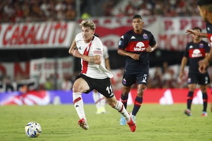 Facundo Colidio se lleva la pelota; lo observa Bruno Leyes