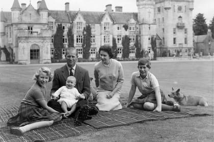FAMILIA JÓVEN. Con su marido y sus hijos, de picnic en Balmoral (1960), haciendo equilibrio entre sus deberes como soberana y como madre.