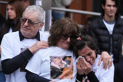 Familiares de Daniel Sebastián Oviedo, de izquierda a derecha, su padre Daniel Oviedo, su madre Sandra Altamirano y su hermana Gisel Oviedo, se abrazan afuera del Hospital Italiano durante una protesta exigiendo justicia para él y otras víctimas que murieron después de recibir fentanilo contaminado mientras estaban hospitalizados, en La Plata, Argentina, el jueves 31 de julio de 2025. (AP Foto/Gustavo Garello)