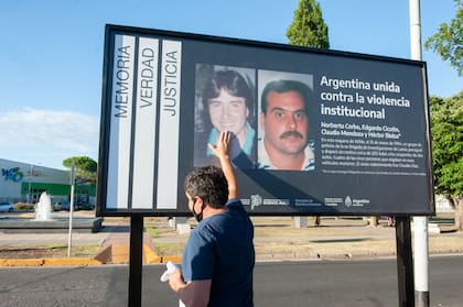 Familiares de las víctimas de la Masacre de Wilde, en el lugar donde se instaló un cartel recordatorio
