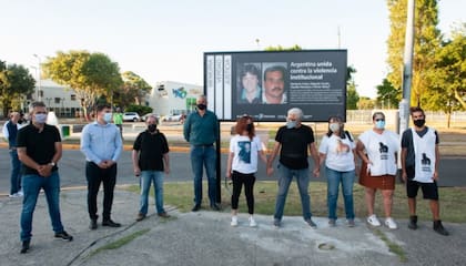 Familiares de las víctimas de la Masacre de Wilde, en el lugar donde se instaló un cartel recordatorio