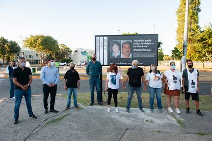 Familiares de las víctimas de la masacre de Wilde, en el lugar donde se instaló un cartel recordatorio