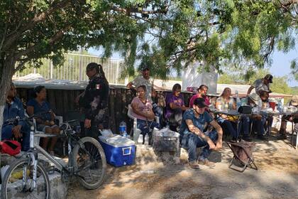 Familiares de mineros atrapados en una mina de carbón colapsada e inundada esperan información afuera de la mina en Sabinas, en el estado mexicano de Coahuila, el jueves 4 de agosto de 2022.  (AP Foto/Elizabeth Monroy)