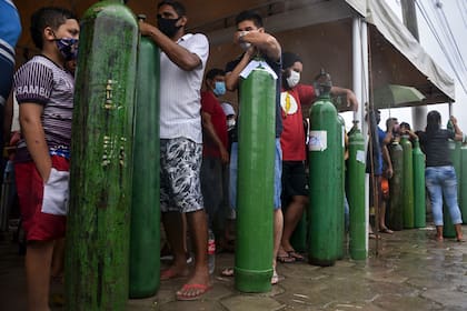 Familiares de pacientes infectados con Covid-19 hacen cola durante largas horas para recargar sus tanques de oxígeno en la empresa Carboxi en Manaos, estado de Amazonas, Brasil, el 19 de enero de 2021