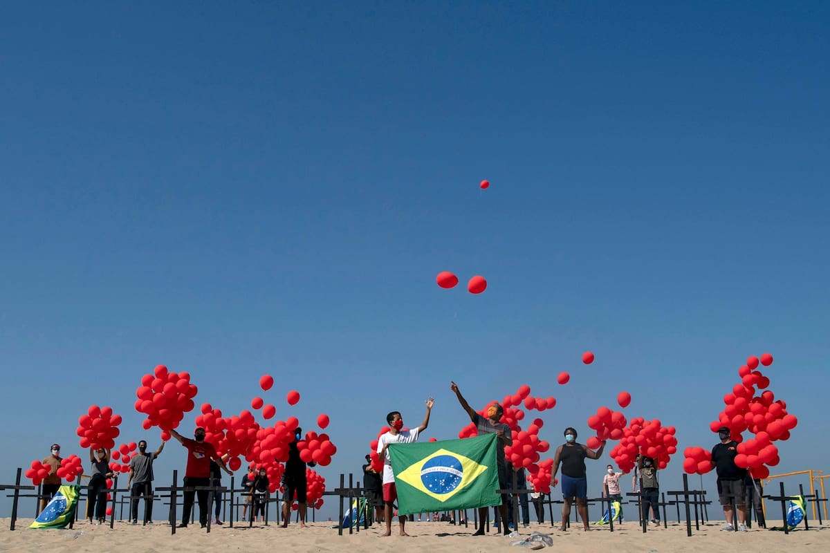 Familiares de un fallecido por COVID-19, junto a una ONG, sueltan globos rojos en homenaje a las víctimas del virus. Copacabana, Río de Janeiro, el 8 de agosto de 2020.