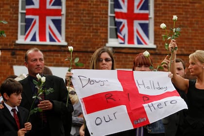 Familiares de un soldado británico caído en Afganistán flanquean la calle al paso de su féretro, en Wootton Bassett, Inglaterra (Archivo)