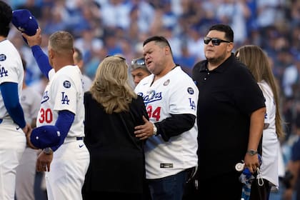 Familiares del fallecido exlanzador mexicano Fernando Valenzuela se unen a los Dodgers de Los Ángeles durante un minuto de silencio antes del primer juego de la Serie Mundial ante los Yankees de Nueva York, el viernes 25 de octubre de 2024 (AP Foto/Godofredo A. Vásquez)