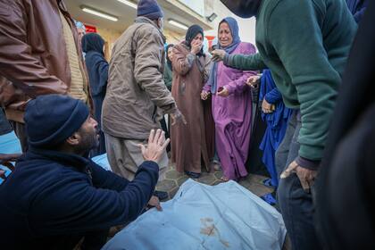 Familiares lloran mientras los cuerpos de las víctimas de los ataques del ejército israelí durante la noche en varios lugares del centro de la Franja de Gaza son depositados juntos para las oraciones fúnebres, en el Hospital de los Mártires de Al-Aqsa en Deir al-Balah, viernes 3 de enero de 2025. (AP foto/Abdel Kareem Hana)