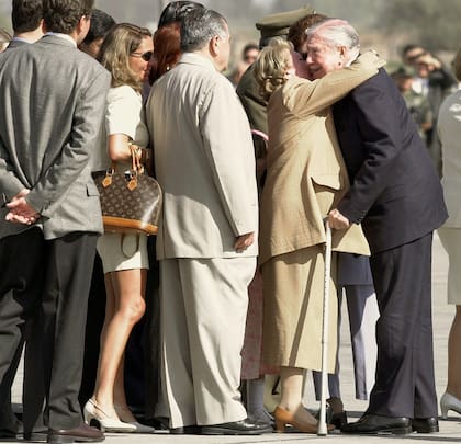 Familiares y amigos hacen fila para saludar al general Augusto Pinochet a su llegada a una base de la Fuerza Aérea en el aeropuerto de Pudahuel, en Santiago de Chile, el viernes 3 de marzo de 2000.(AP Photo/Roberto Candia)
