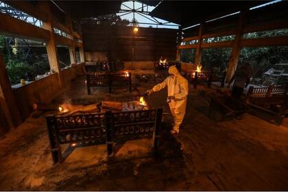 Familiares y empleados municipales practican los ritos fúnebres a las víctimas de covid-19 en un centro de cremación en Bombay