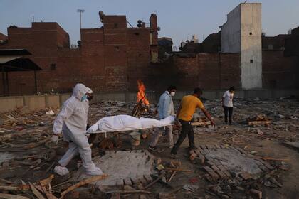 Familiares y voluntarios cargando el cuerpo de una víctima de Covid-19 para ser incinerada en Nueva Delhi, India. (AP Foto/Amit Sharma, archivo)