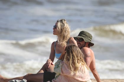 Sentados en la orilla, Benjamín Vicuña, Anita Espasandin y Magnolia compartieron un momento de juegos y conexión. Mientras los grandes optaron por protegerse del sol con lentes oscuros y gorros, la pequeña Magnolia se tapó con un pareo playero