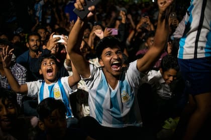 Fanáticos de Argentinaen Kochi, estado de Kerala, India, celebran mientras ven en una pantalla gigante el primer gol de su equipo durante el partido de fútbol final del Mundial entre Argentina y Francia en Qatar