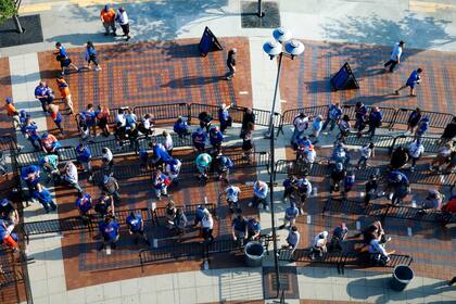 Fanáticos de los Mets de Nueva York forman fila frente al parque, para el juego del 26 de mayo de 2021, ante los Rockies de Colorado, que terminó aplazándose ante la amenaza de lluvia (AP Foto/Noah K. Murray)