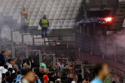 Fanáticos del club holandés Feyenoord arrojan bengalas a la cancha en el partido de vuelta contra Olympique de Marsella, en las semifinales de la Liga Europa Conferencia, en Marsella, el jueves 5 de mayo de 2022. (AP Foto/Daniel Cole)