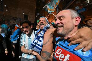 Fans of SSC Napoli gathering at the Largo Maradona in the Quartieri Spagnoli district on May 4, 2023 in Naples to watch a live broadcast of a potentially decisive match between Udinese and Napoli played in Udine, react after Napoli scored an equalizer, anticipating the celebration of the club's Italian champions "Scudetto" title, as Napoli is to play a potentially decisive match in Udine. - Napoli has been waiting 33 years to be named Italian champions, and a potentially decisive game on May 4 against Udinese in Udine may secure the title. (Photo by Alberto PIZZOLI / AFP)
