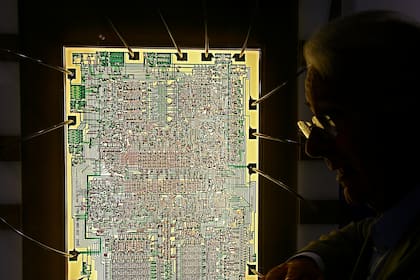 Federico Faggin, el ingeniero detrás del desarrollo del chip Intel 4004, posa con el diseño utilizado por la calculadora de la extinta compañía japonesa Busicom