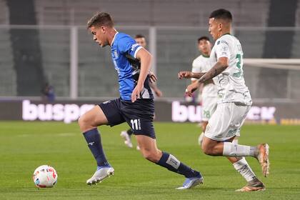 Federico Girotti, de Talleres, se lleva la pelota ante la marca de Emanuel Coronel, de Banfield