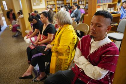 Feligreses rezan durante un servicio en idioma karen en la Iglesia Bautista Indian Lake, mientras celebran 15 años de asociación con la congregación de 150 años fundada por inmigrantes suecos, en Worthington, Minnesota, el domingo 20 de octubre de 2024. (AP Foto/Jessie Wardarski)