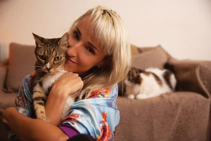 Fenna, junto a uno de sus gatos, posa en el living de su casa.